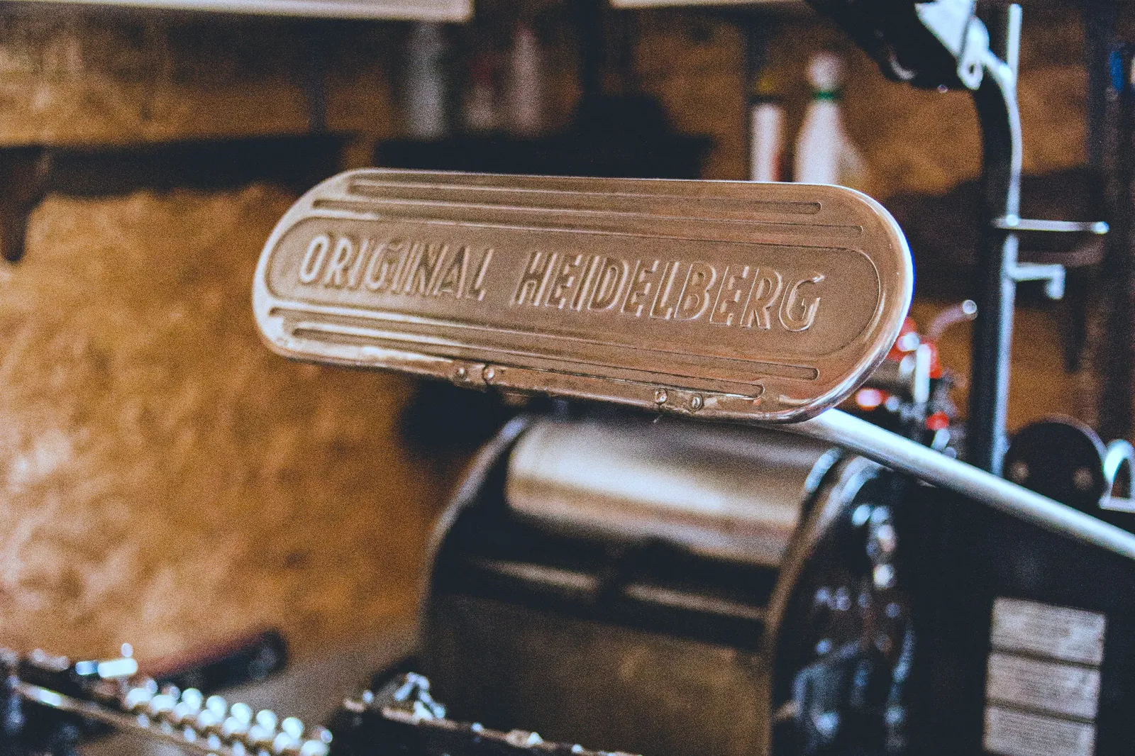 Close-up of a cast-iron letterpress machine in a workshop, its rollers and frame visible