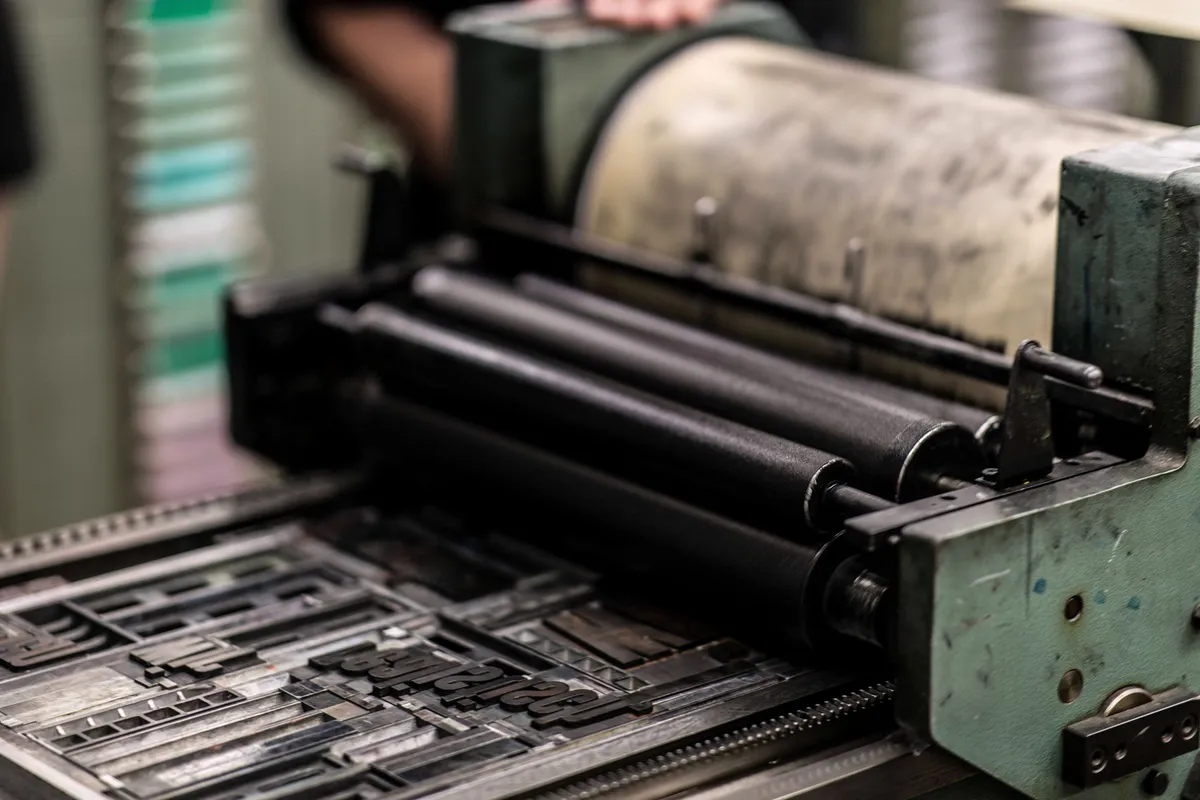The drive gears and linkages of an industrial printing press, finished in green and black